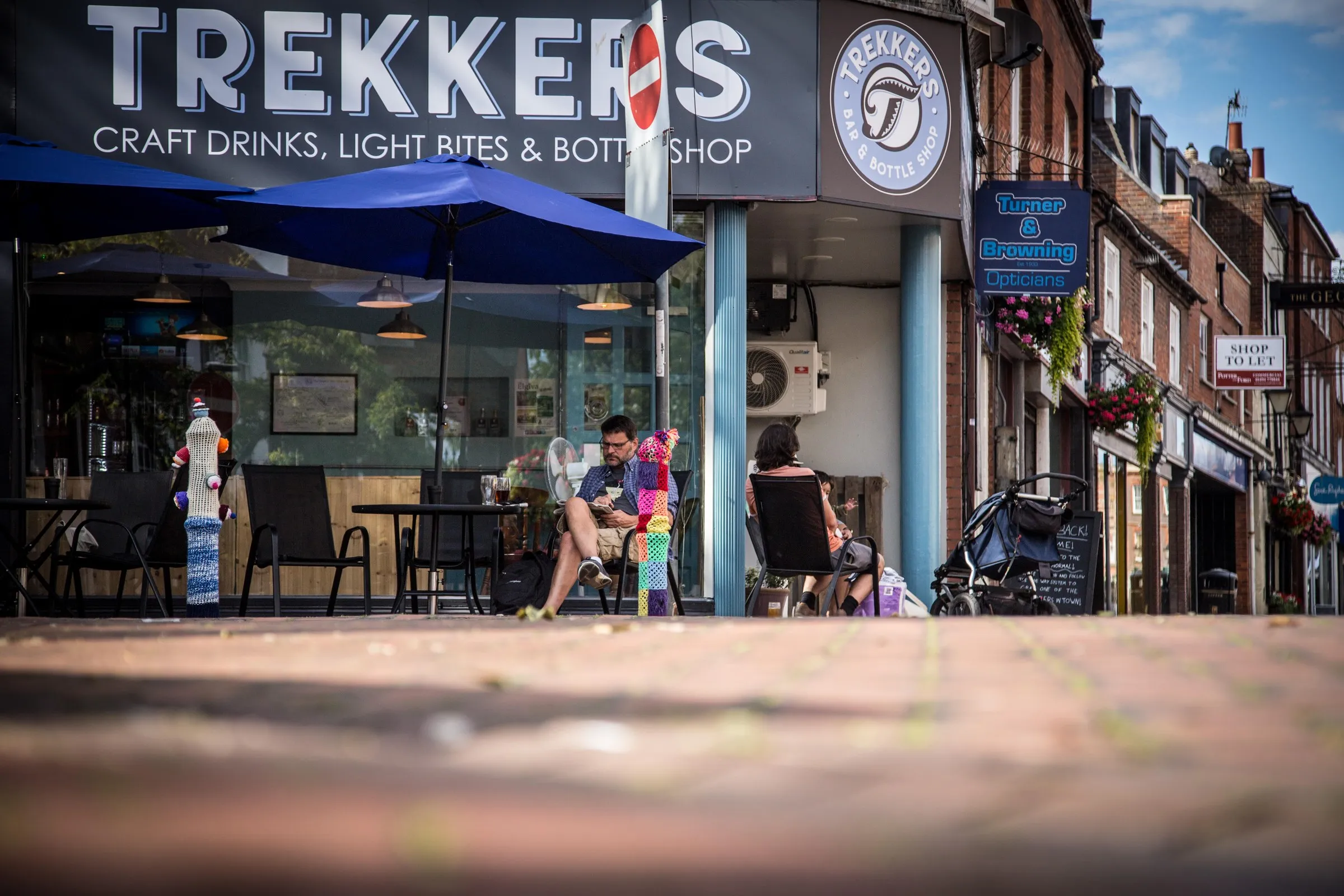 Sunny outdoor seating under blue umbrellas outside Trekkers on Chesham High Street