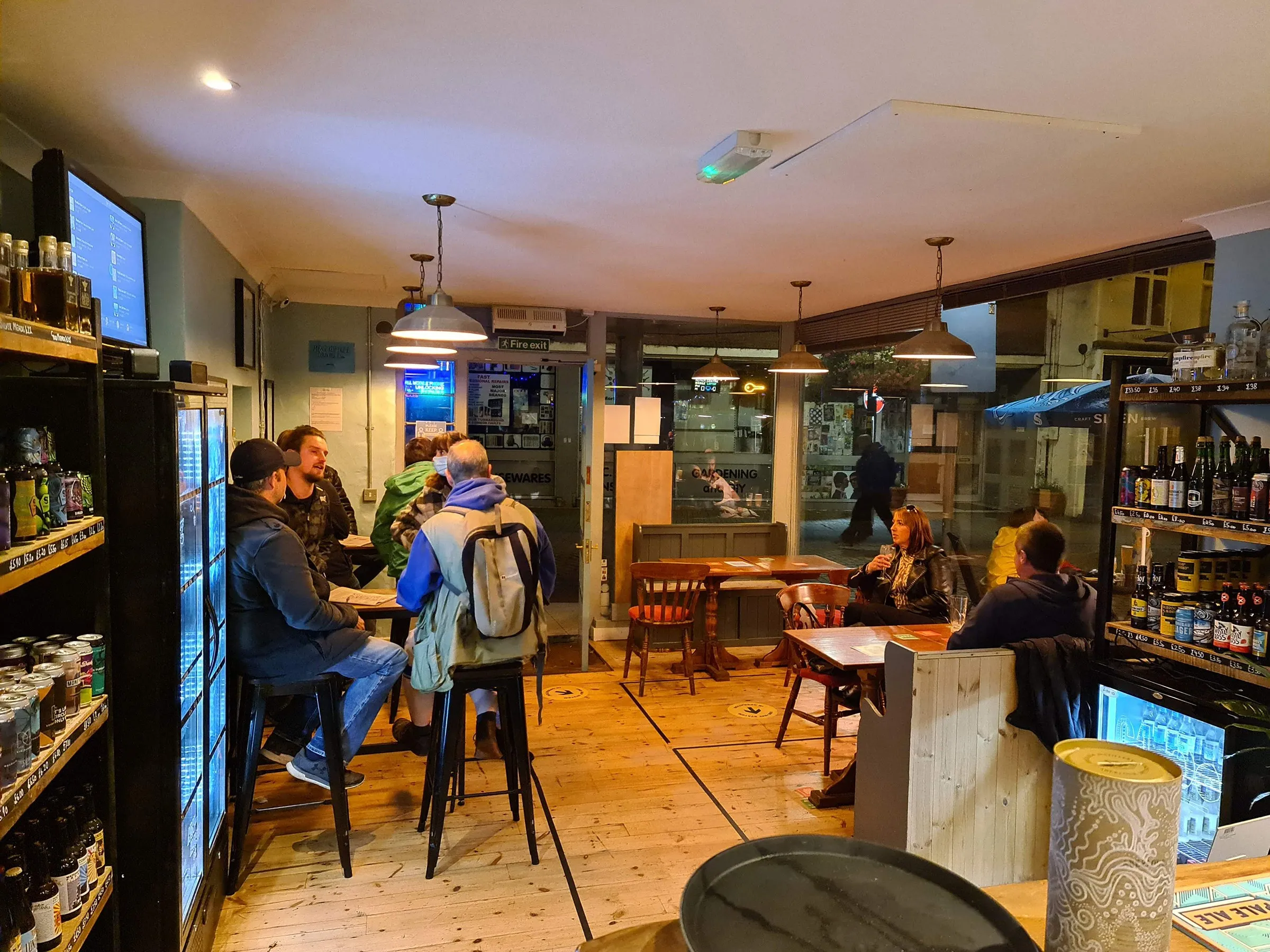 Inside Trekkers: customers at tables beside the fridges and shelves